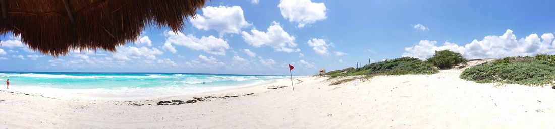 Scenic view of beach against cloudy sky