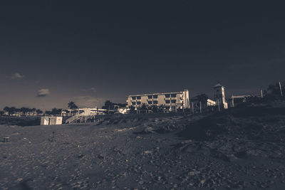 Scenic view of beach by buildings against sky