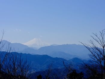 Scenic view of snowcapped mountains against clear blue sky