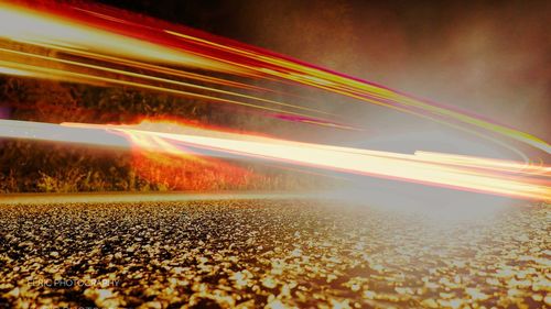Light trails on road against sky at night