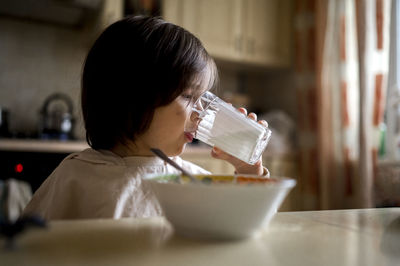 Boy drinking milk from glass at home