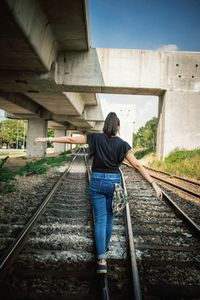 Rear view of man standing on railroad track