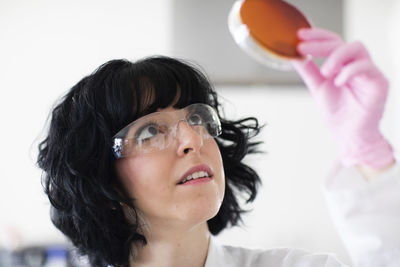 Young woman scientist portrait with gloves and safety glass