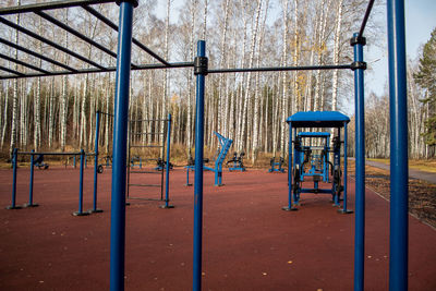 Empty playground against clear blue sky in park
