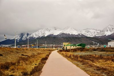 Road amidst snowcapped mountains against sky