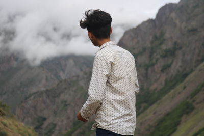 Side view of man standing against mountain