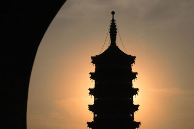 Low angle view of silhouette building against sky during sunset