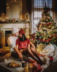 Couple romancing while sitting at home during christmas