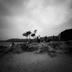 People walking on land against sky