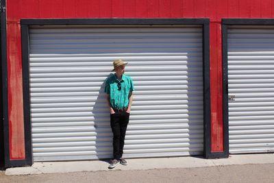 Full length of man standing against shutter