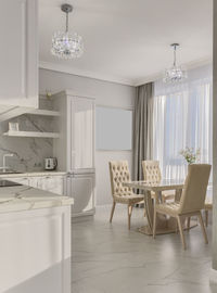 Sunny bright kitchen in classic style in light colors with marble and table