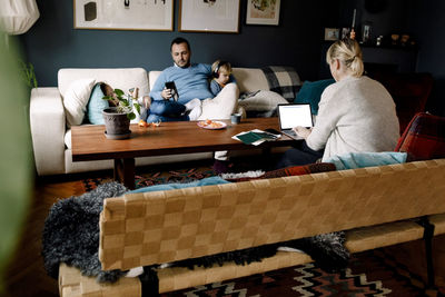 Family using various technologies in living room