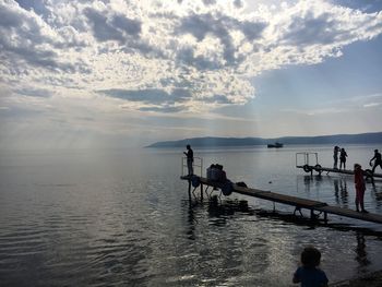 People by sea on jetty