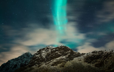 Scenic view of aurora borealis and mountains against sky at night