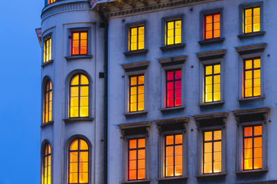 Colorful illuminated windows on building at dusk