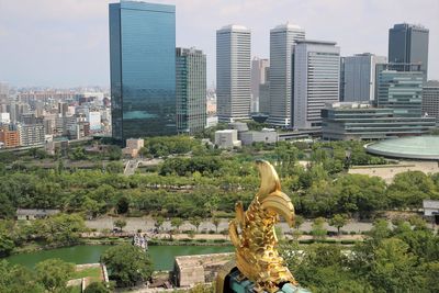 Rear view of statue against buildings in city