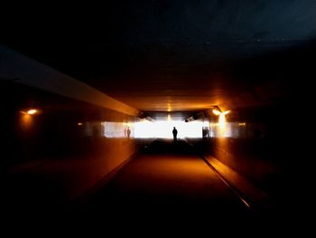 People walking in illuminated tunnel