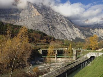 Arch bridge over mountains against sky