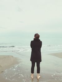 Full length of man standing on beach against sky