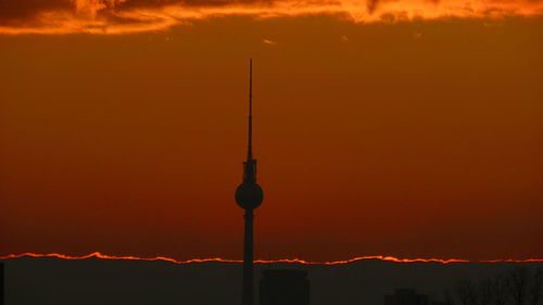 Silhouette of communications tower during sunset