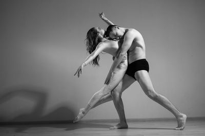 Full length of couple dancing against white background