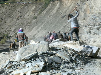 Rear view of people walking on rocks