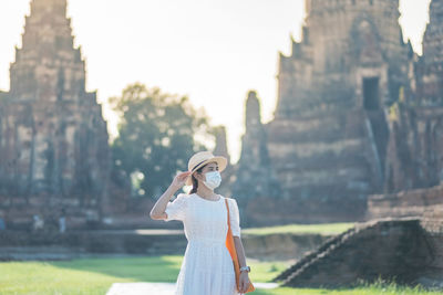 Woman standing against built structure