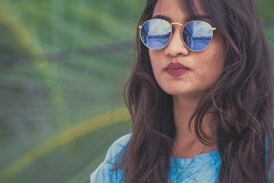 Close-up portrait of woman wearing sunglasses while standing outdoors