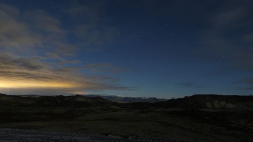 Scenic view of landscape against sky at night