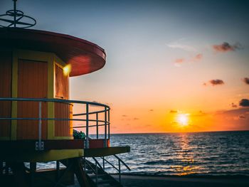 Lifeguard hut against sky during sunset