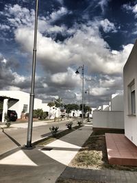View of city street against cloudy sky