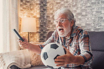 Man playing soccer ball at home