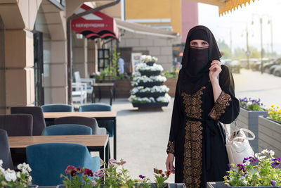 Young slender muslim woman black clothes on the streets of dubai. person