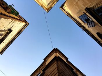 Low angle view of buildings against clear blue sky