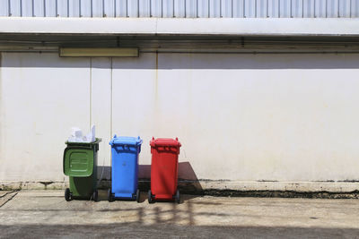 Garbage bin against wall in city