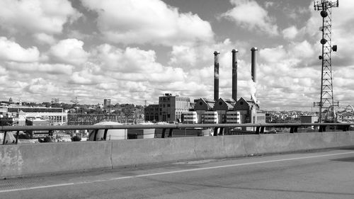 Smoke stacks by city against sky