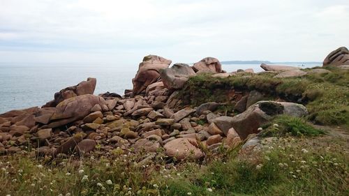 Rocks in sea against sky