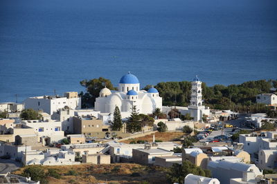 High angle view of townscape by sea against sky