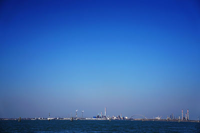 Sailboats in sea against clear blue sky