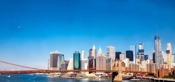 Brooklyn bridge over east river against skyscrapers in city