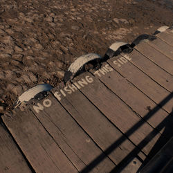 High angle view of information sign on pier at beach