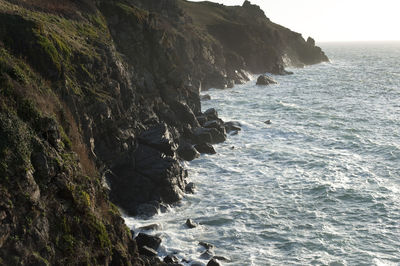 Idyllic view of sea by cliff