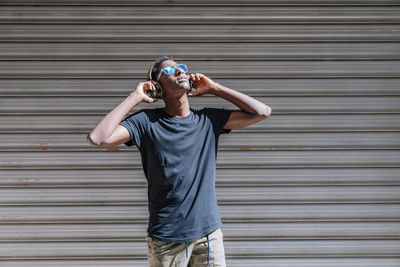 Full length of teenage boy standing against wall