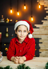 Happy funny child boy in red christmas shirt near christmas tree