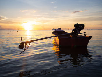 Silhouette person in sea against sky during sunset