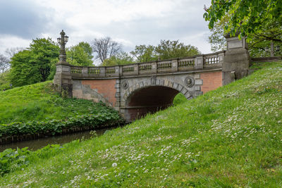 Arch bridge over river against sky