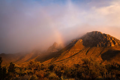 Scenic view of mountains against sky and rainbow