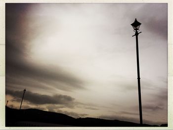 Silhouette of building against cloudy sky