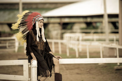 Full length of young woman standing by railing