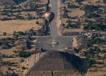 High angle view of hot air balloon flying over landscape